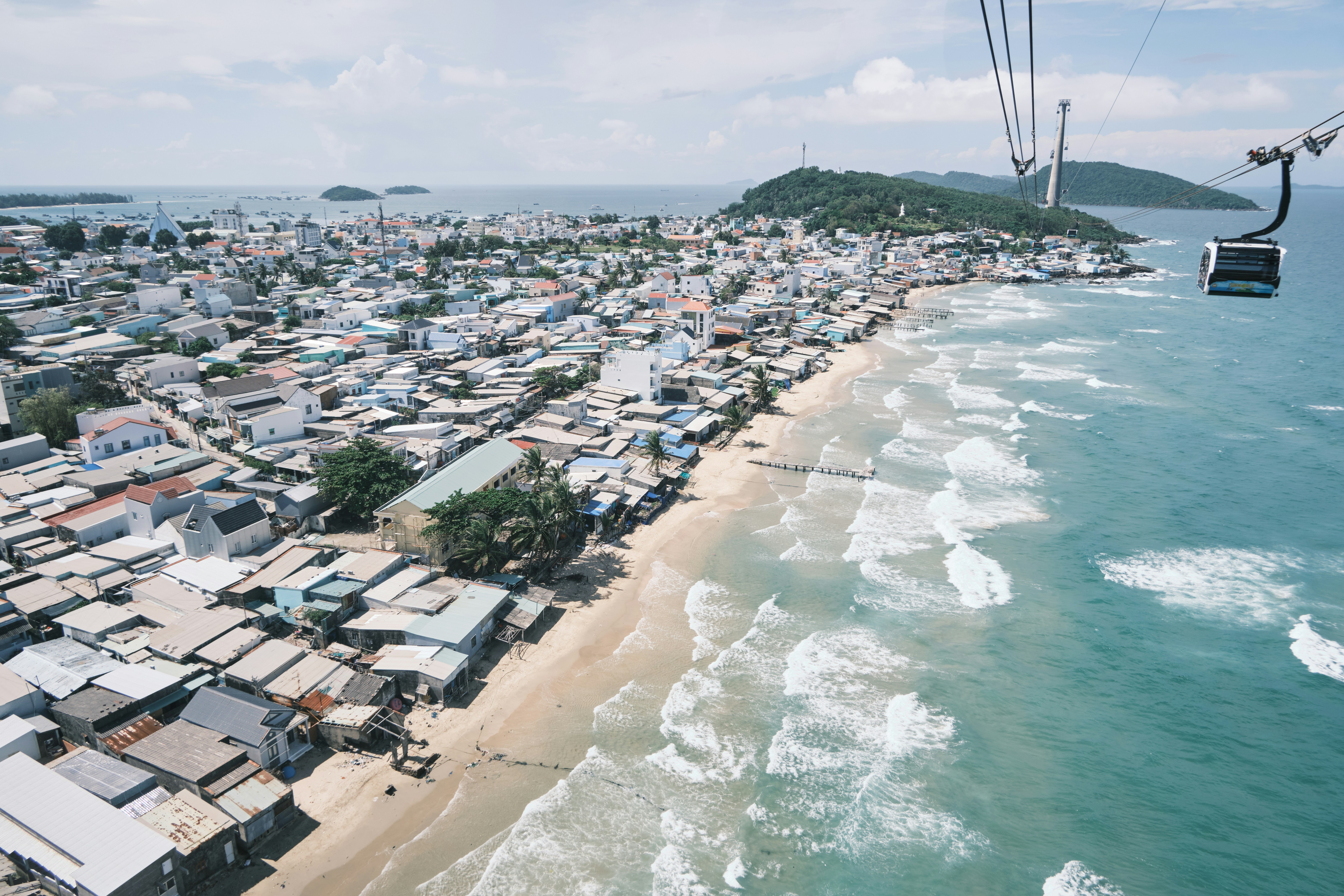 Kalkfelsen mit spärlicher Vegetation und einzelnen Bäumen unter blauem Himmel.