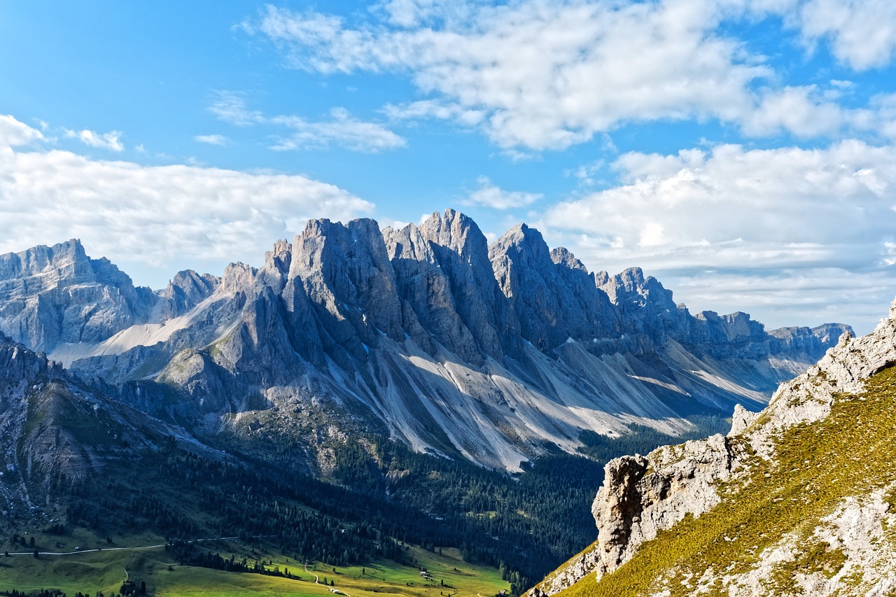 Kalkfelsen mit spärlicher Vegetation und einzelnen Bäumen unter blauem Himmel.